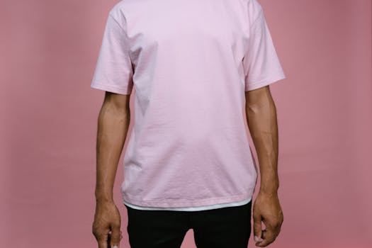 Person in a casual pink t-shirt stands against a plain background.