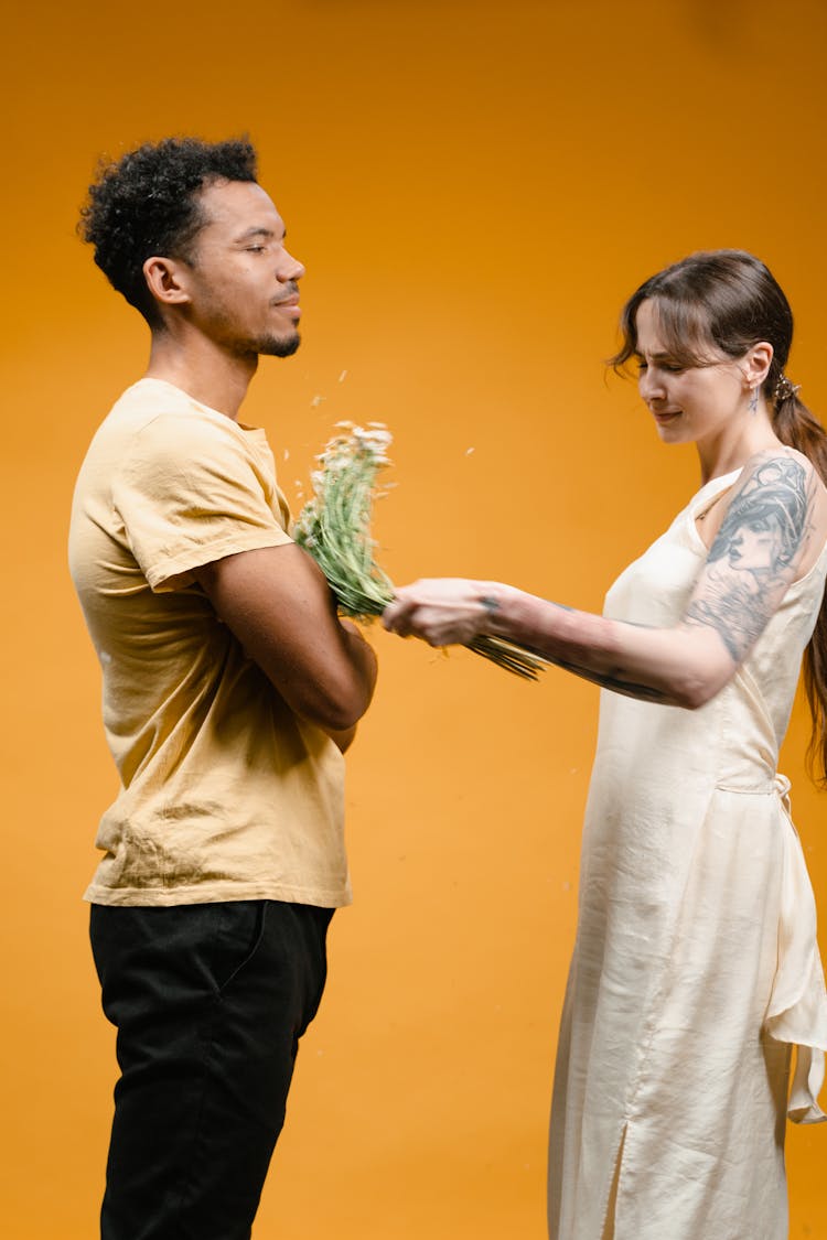 Woman In A Long Dress Hitting A Man With A Bunch Of Flowers