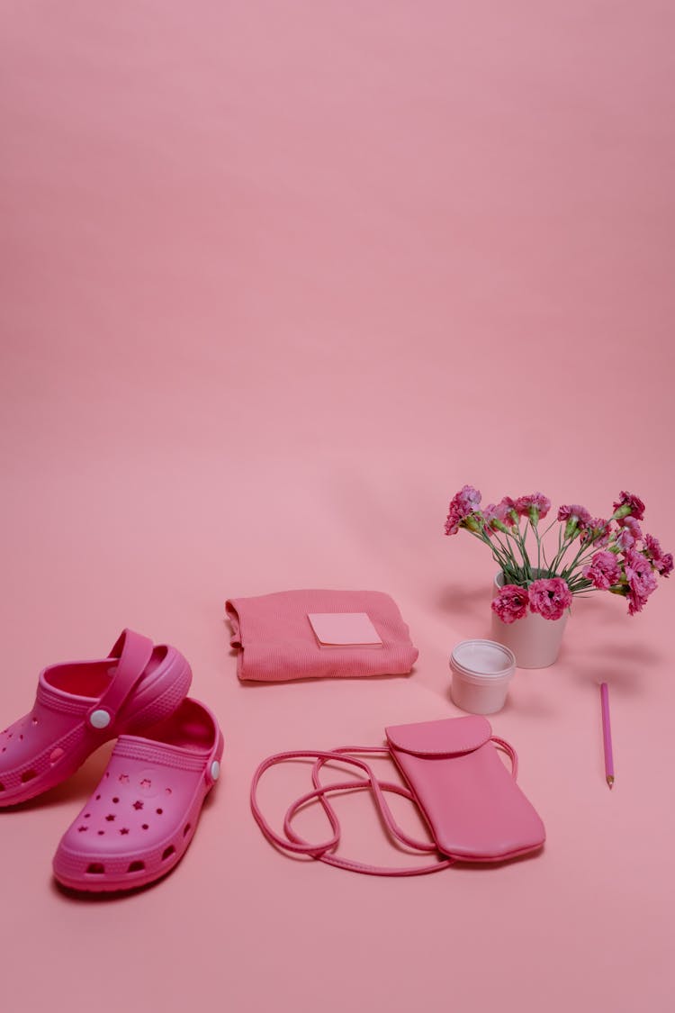 Pink Rubber Clogs Near Pink Bags On Pink Bakcgorund 