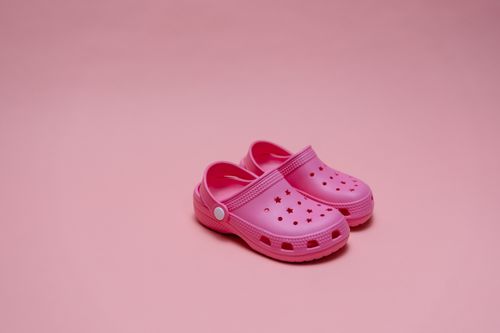 Free Vivid pink rubber clogs paired with matching monochromatic pink background. Stock Photo