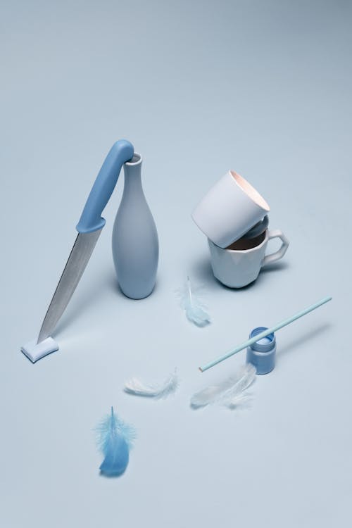 White Ceramic Mug With Spoon Beside Blue and White Plastic Spoon