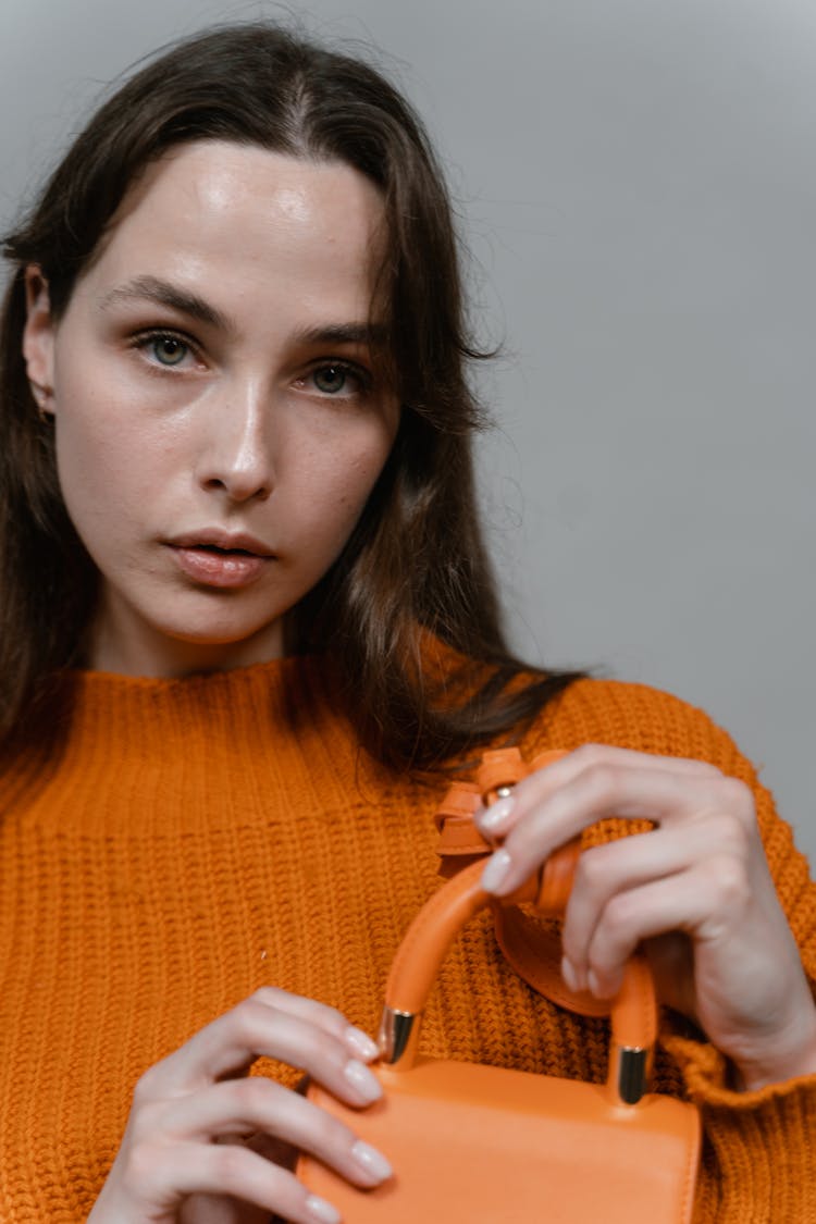 Woman In Orange Knit Sweater Holding A Orange Mini Handbag 