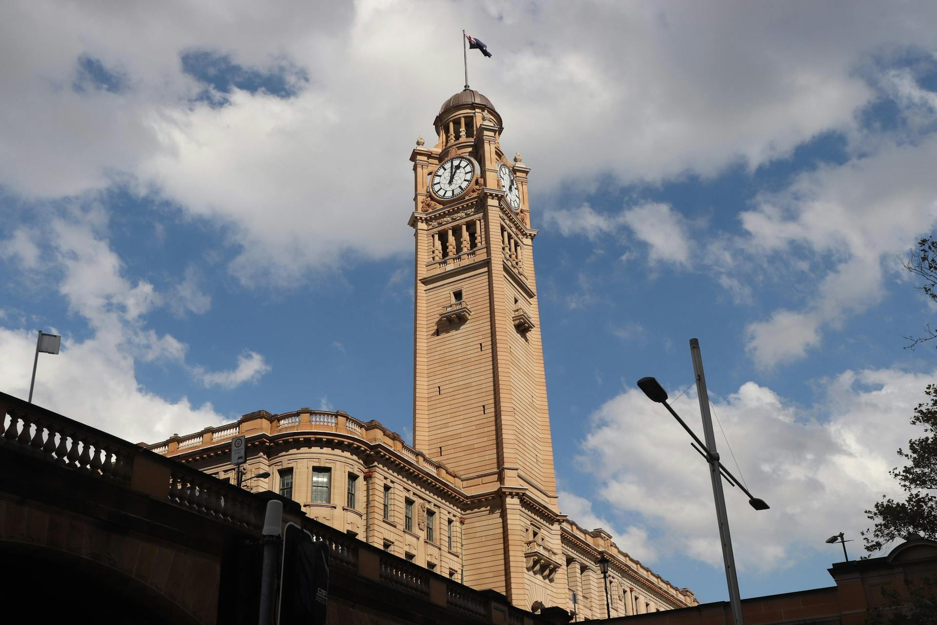 Majestic view of the iconic Sydney Central Station's clock tower under a clear blue sky.