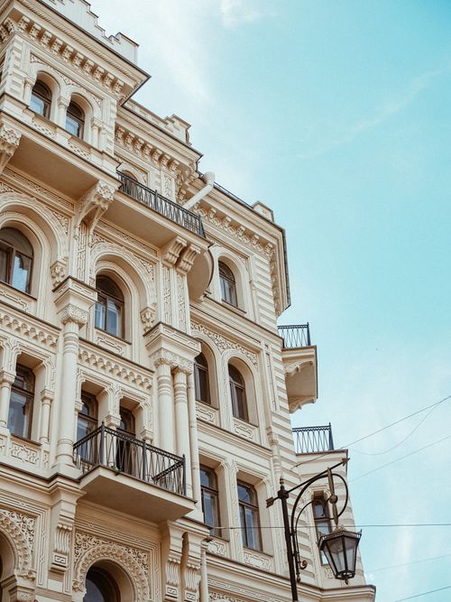 Free A detailed shot of an ornate historical building with balconies against a clear blue sky. Stock Photo