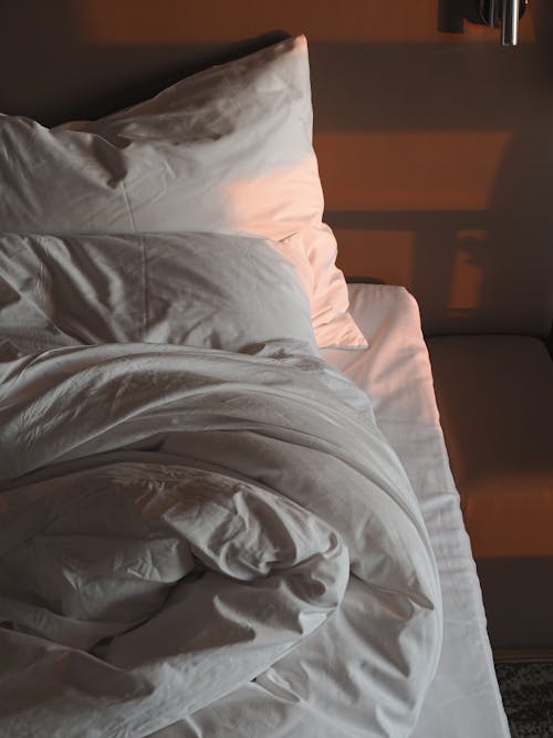Free Bed with White Pillows and Blanket Stock Photo