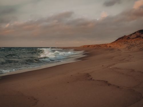 Free Explore the serene and dramatic coastline of Kaliningrad with waves crashing under a moody twilight sky. Stock Photo