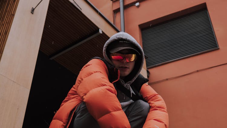 Young Man In A Puffer Jacket Wearing Reflective Sunglasses 