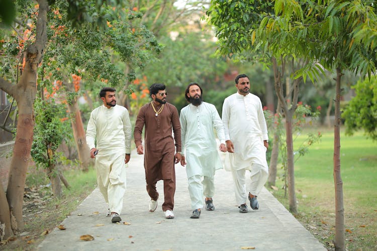 Group Of Men In Traditional Clothes Walking In Park