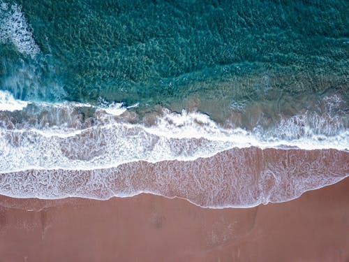 Aerial Photography of Beach Waves with Seafoam on the Shore