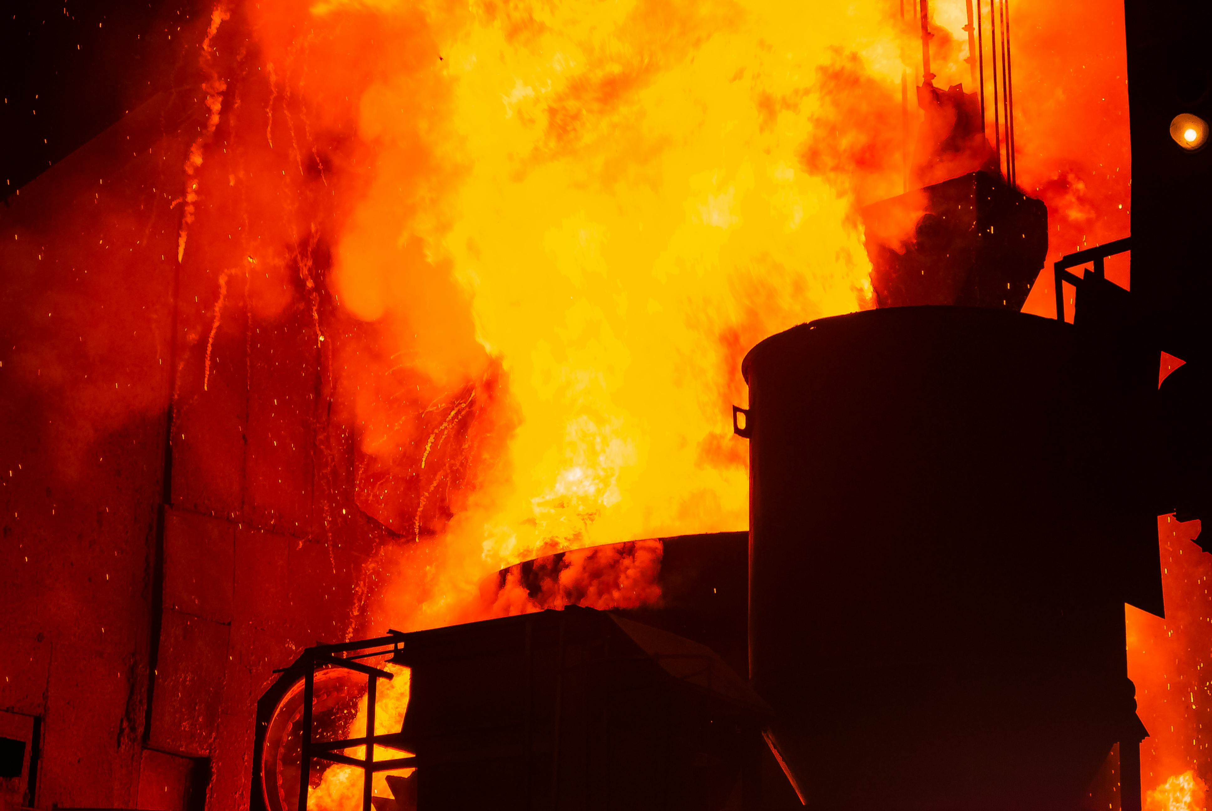 A powerful image of an industrial furnace with intense flames and sparks creating a dramatic scene.