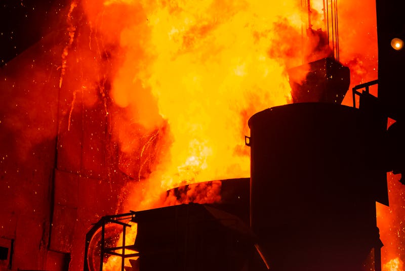A powerful image of an industrial furnace with intense flames and sparks creating a dramatic scene.