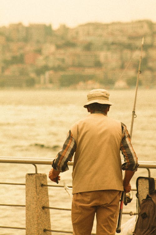 Man Holding a Fishing Rod Near the River
