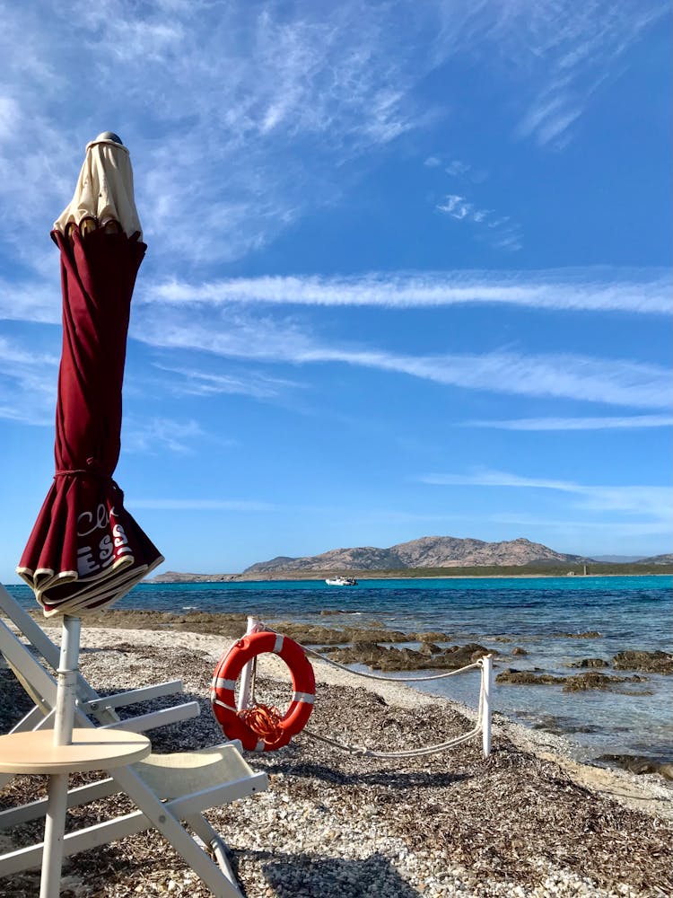 Folded Outdoor Umbrella Near The Seashore
