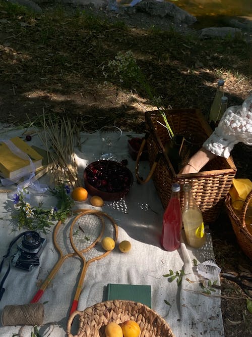 A Pair of Wooden Badminton Rackets on a Picnic Blanket with Yellow Apples