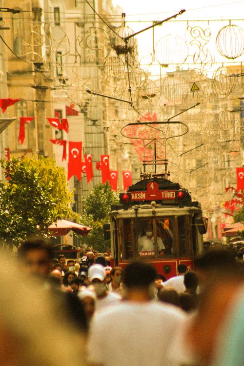 Free Historic red tram navigating a bustling street in Istanbul adorned with Turkish flags. Stock Photo