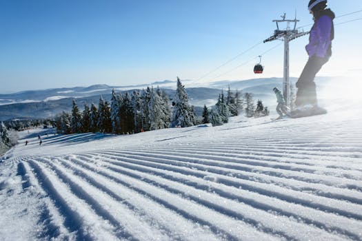 Winter scene of skiers on a snowy slope with cable car and clear sky