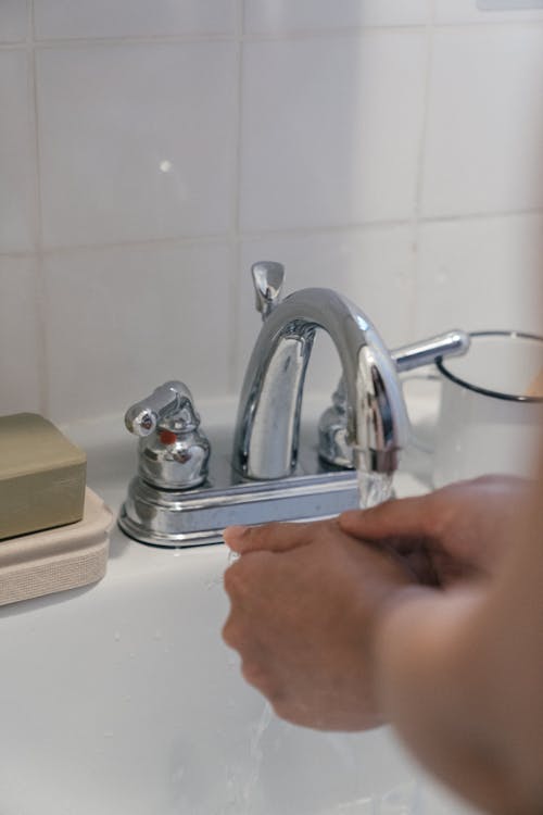 Photo of a Person Washing Hands on a Sink