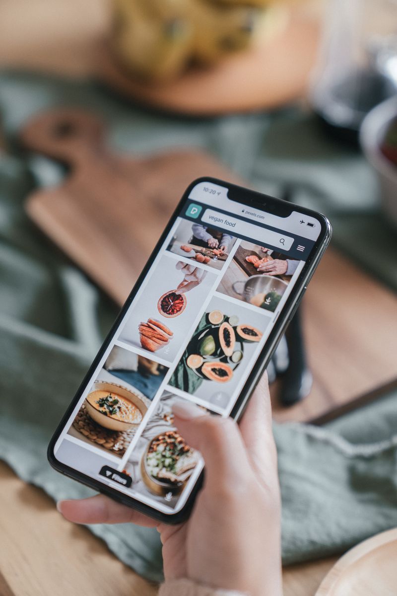 Hand holding a smartphone browsing food recipes
