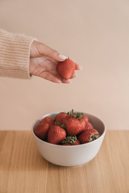 Free Photo of a Person's Hand Holding a Red Strawberry Stock Photo