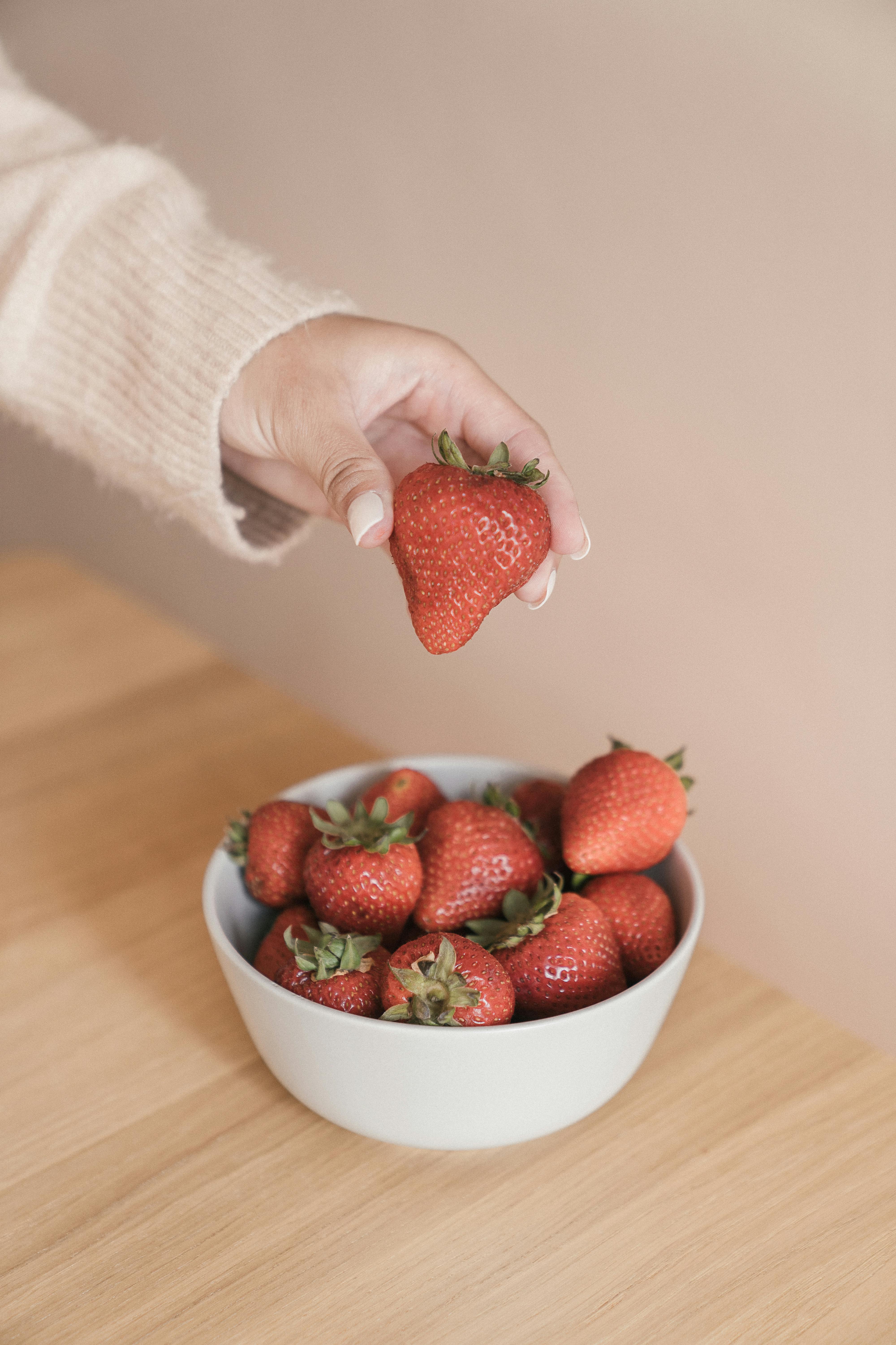 hand of a person holding a fresh strawberry
