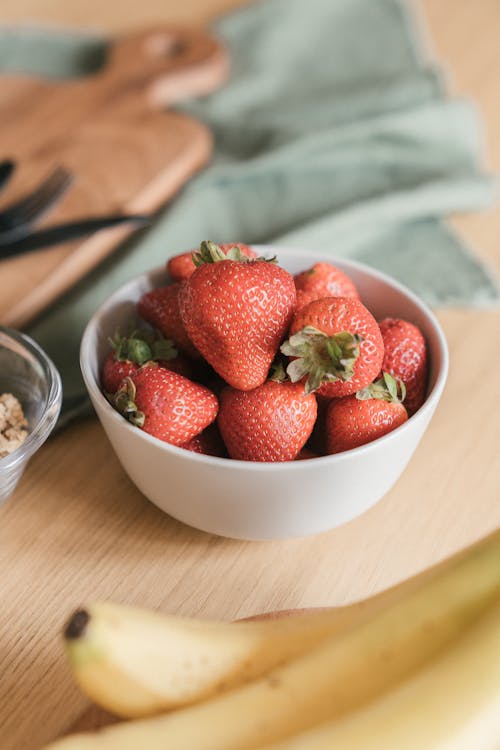 Selective Focus Photo of a White Ceramic Bowl with Red Strawberries