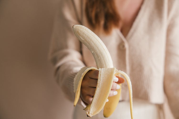 Close Up Shot Of A Person Holding A Banana 