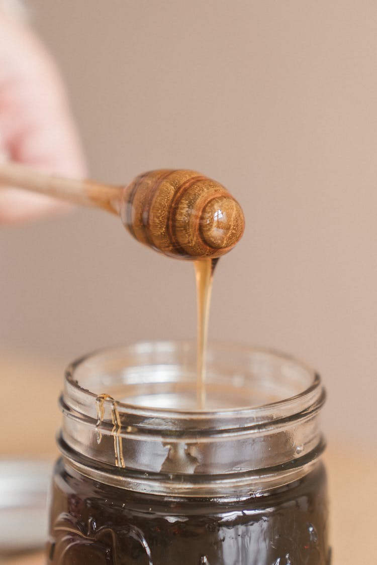 Honey Dripping From A Wooden Dipper