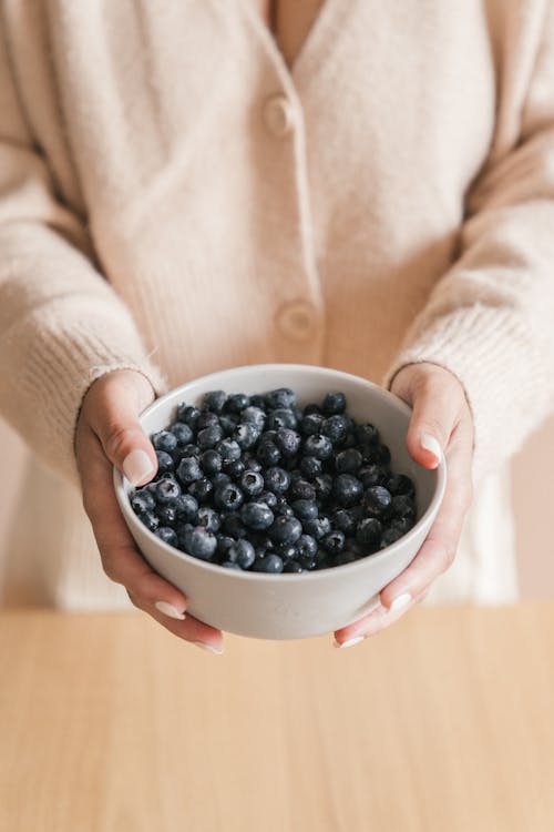 Free Woman Holding a Bowl of Blueberries Stock Photo