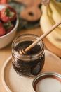 A Wooden Dipper on a Glass Jar of Honey