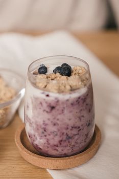 A refreshing blueberry smoothie topped with granola, beautifully captured indoors.