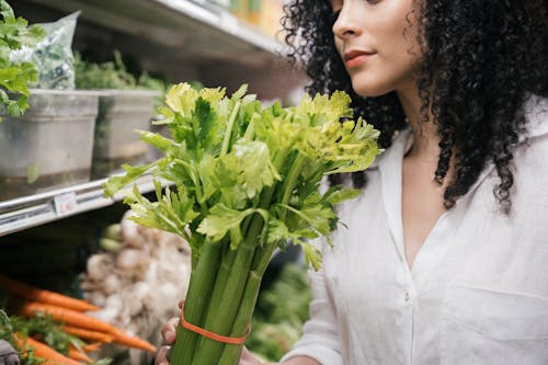 Close up of a Woman Holding a Celery Stalk 