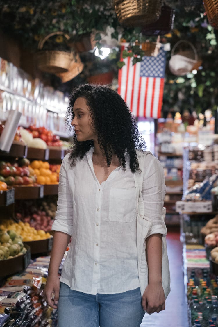 A Woman Looking For Vegetables And Fruits Inside The Market