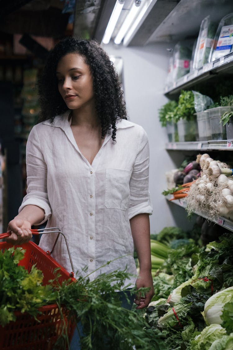 A Woman Holding A Grocery Basket With Vegetables