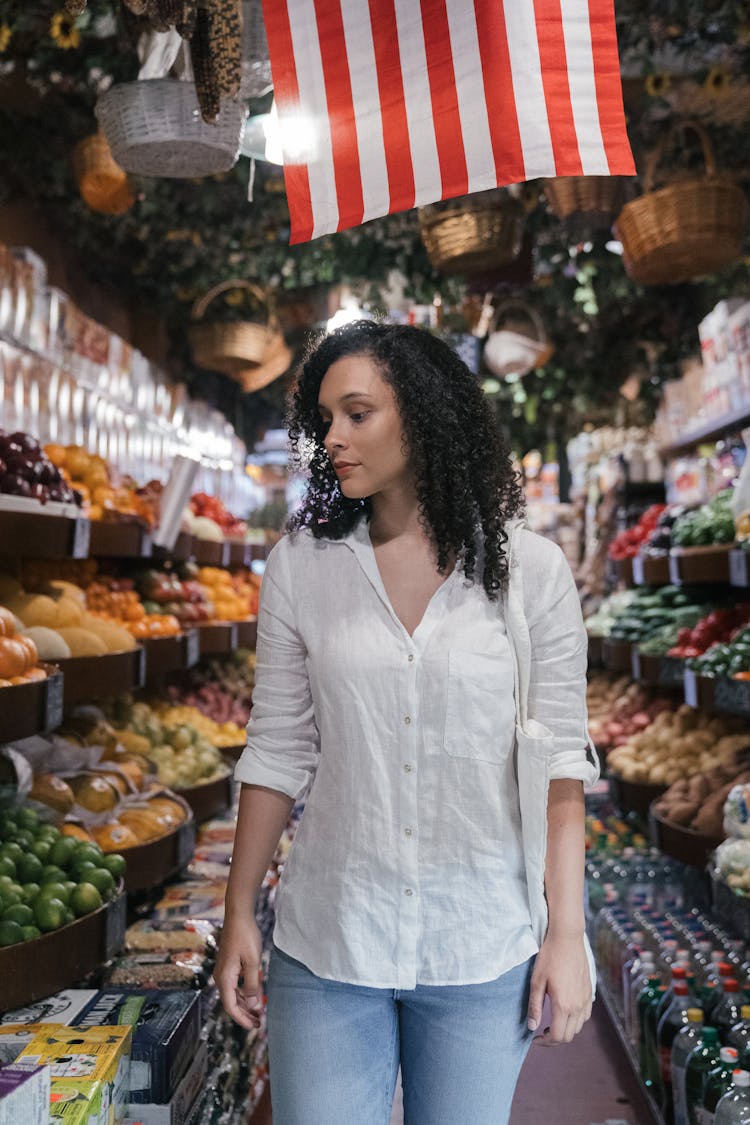 A Woman Looking For Vegetables And Fruits Inside The Market