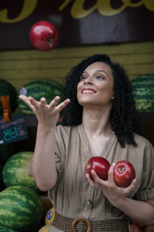 Free A Woman Tossing an Apple in the Air  Stock Photo