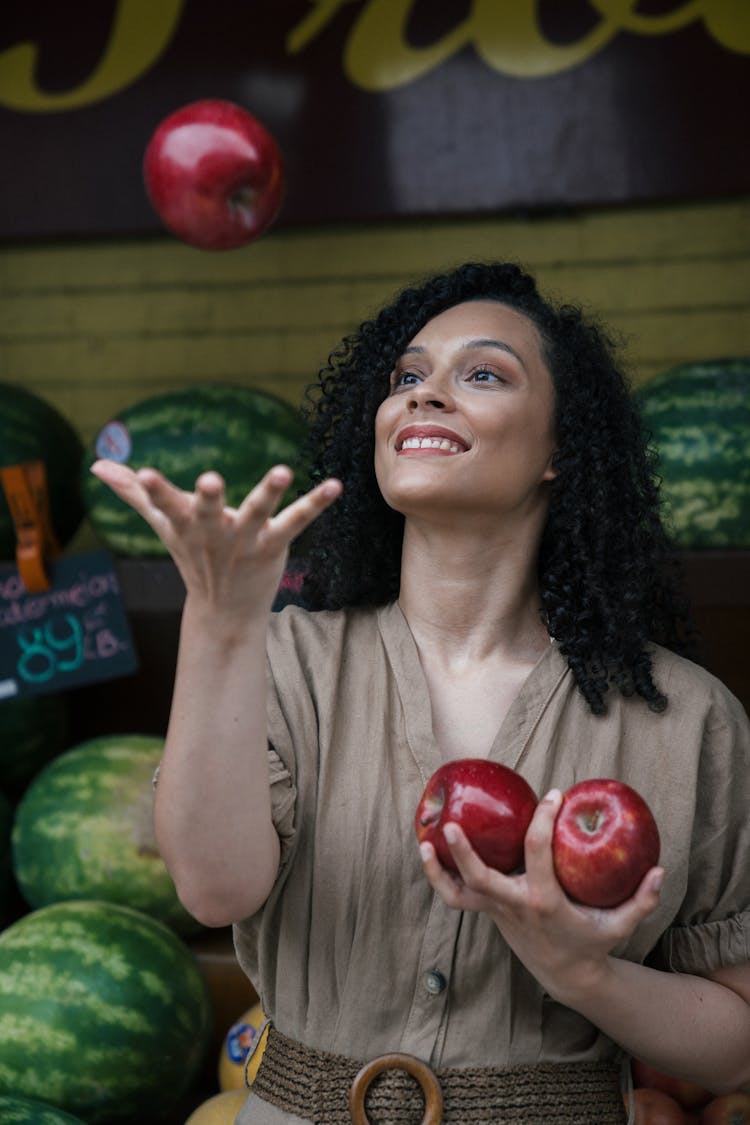 A Woman Tossing An Apple In The Air 