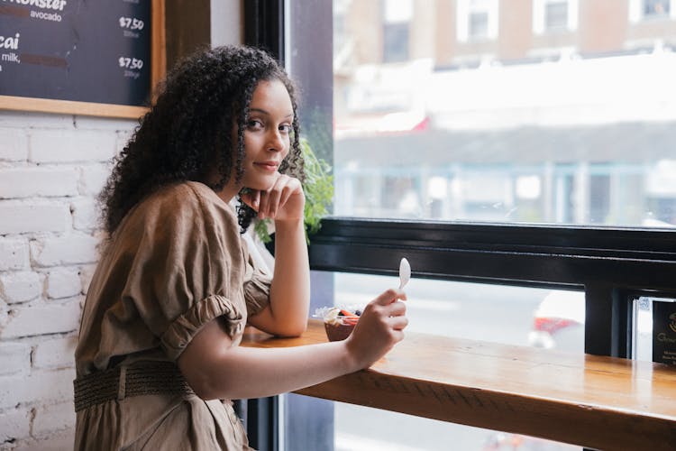 Curly-Haired Woman Sitting Inside A Restaurant