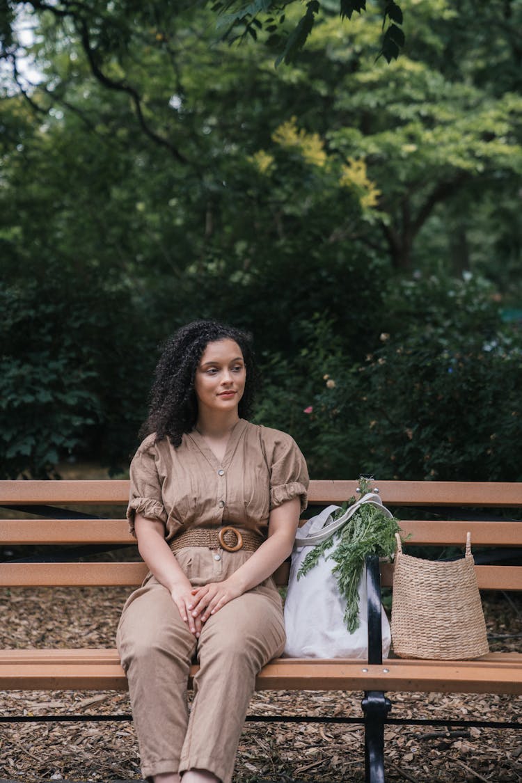 Woman Sitting On Park Bench With Grocery In Bags