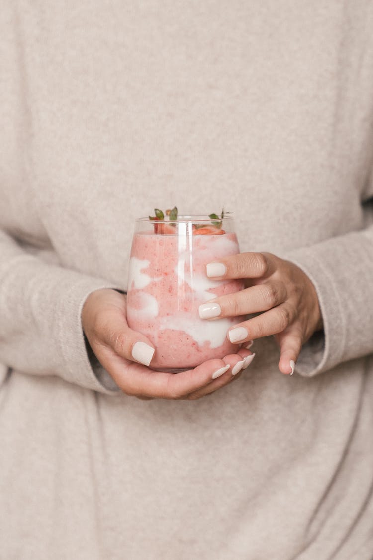 Person Holding A Glass Of Strawberry Smoothie