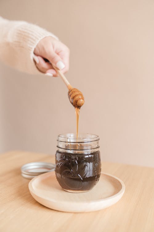 Close-Up Shot of a Person Holding Honey Dipper