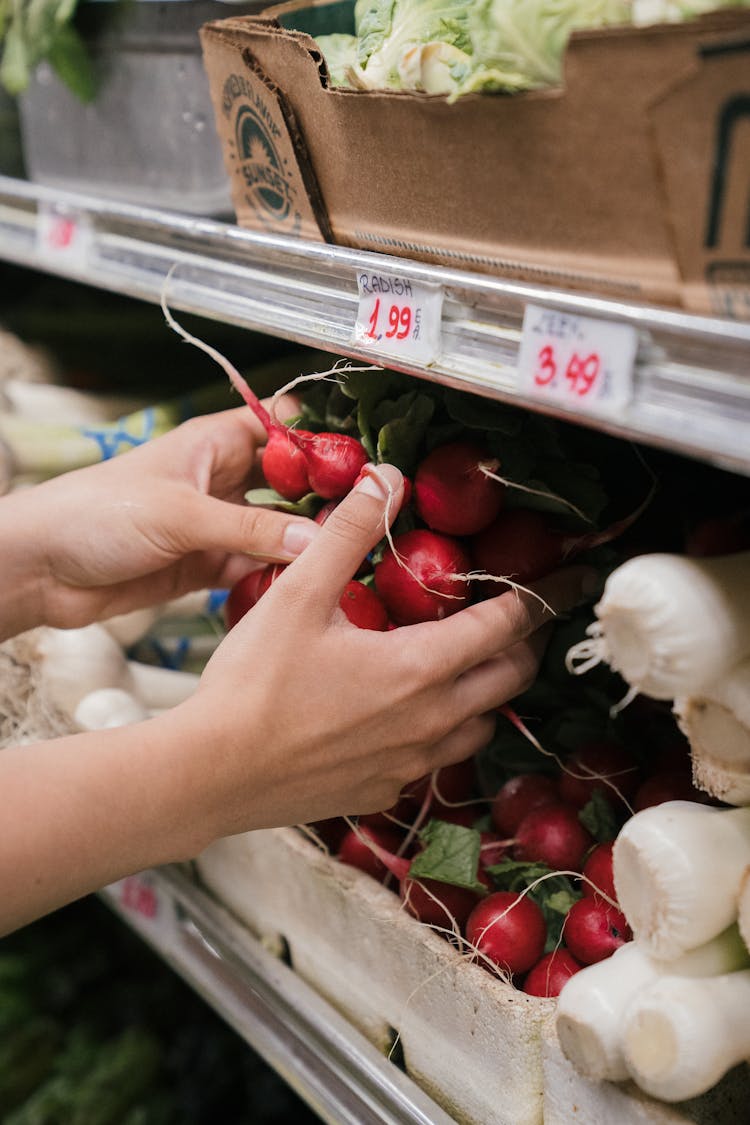 Person Taking Raddish From A Store Shelf 