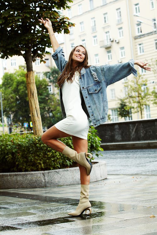 A Woman in Denim Jacket and White Dress Posing
