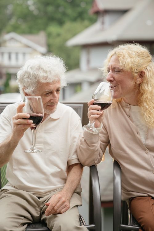 Free Senior couple enjoying a relaxing moment with wine outdoors on a patio. Stock Photo