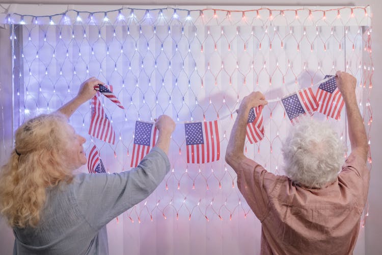 Elderly Couple Handing 4th July Decorations 