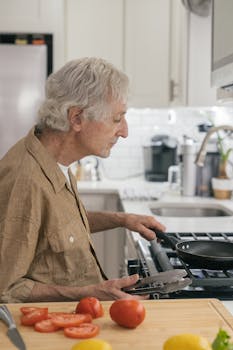 Senior man preparing a meal in a modern kitchen with fresh vegetables.
