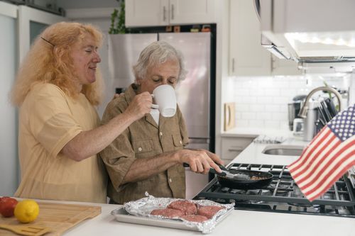 Free Senior couple enjoying cooking together at home, a heartwarming scene of togetherness and love. Stock Photo