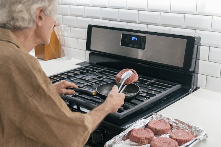 Old Man Frying Beef On Pan