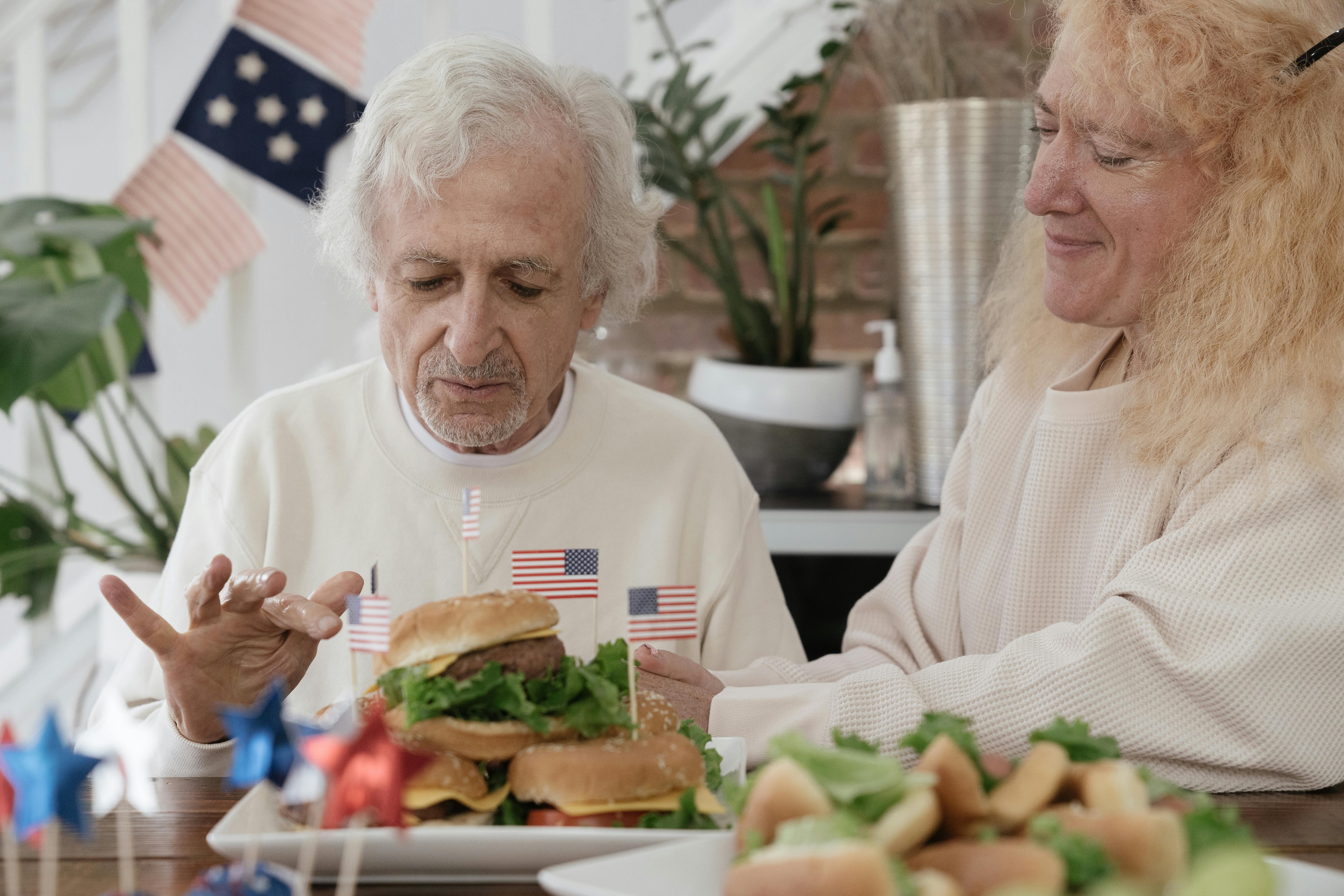 elderly couple eating burgers while celebrating