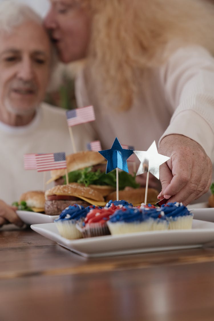 An Elderly Couple Celebrating Fourth Of July With Food On Table