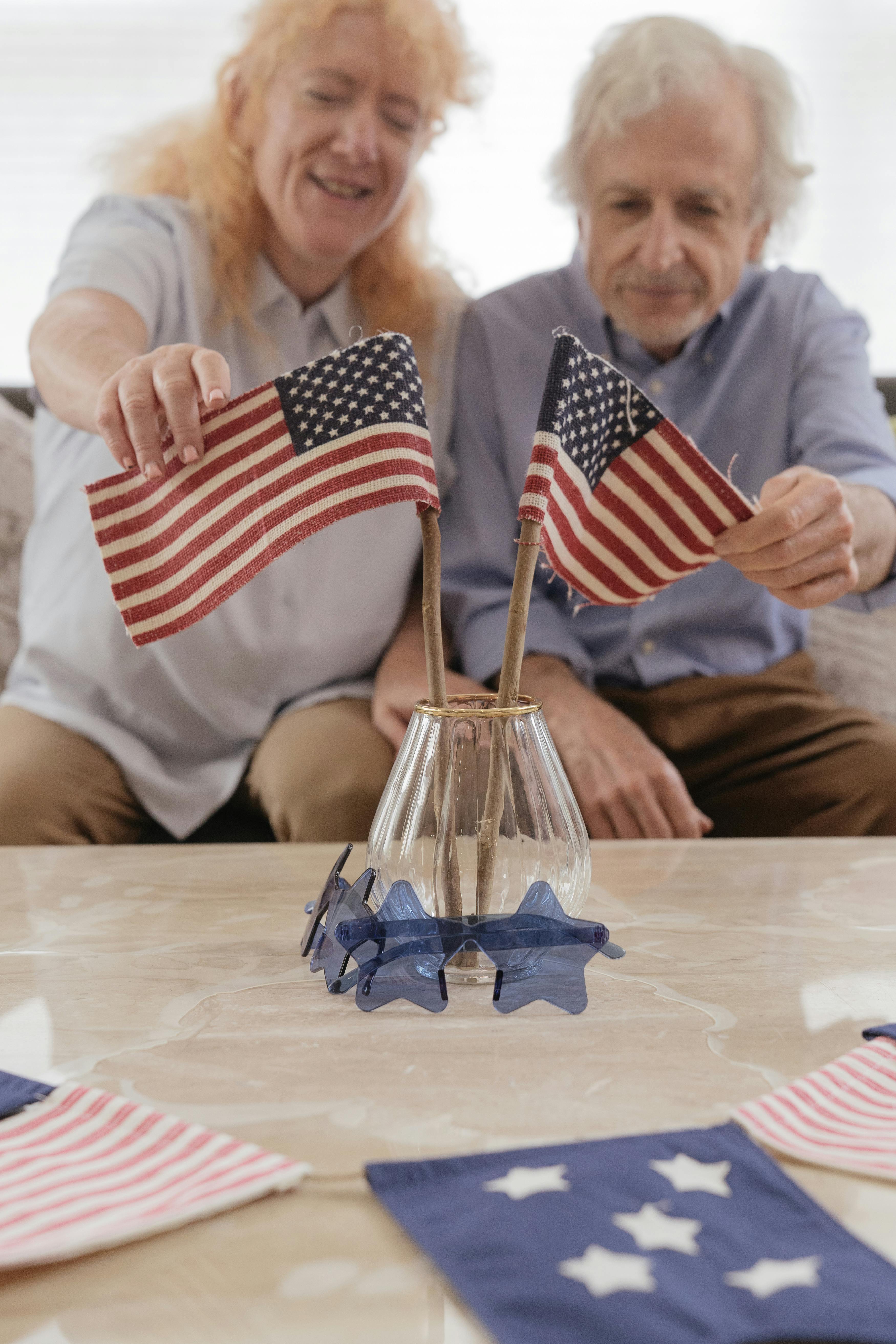 elderly couple holding an american flag